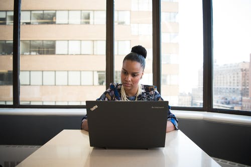 女人坐在沙发上面对联想thinkpad · 免费素材图片