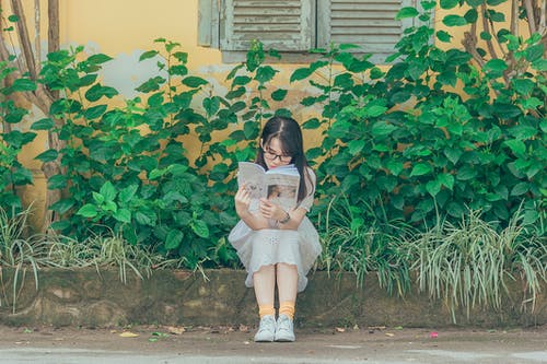 女人穿着白色的衣服看书 · 免费素材图片