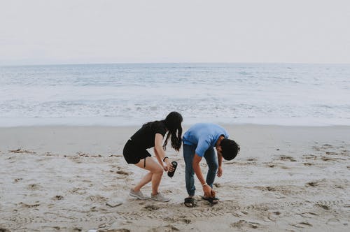 男人和女人站在海边 · 免费素材图片