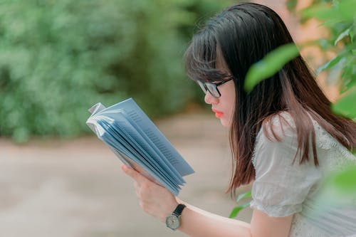 女孩阅读书的特写摄影 · 免费素材图片