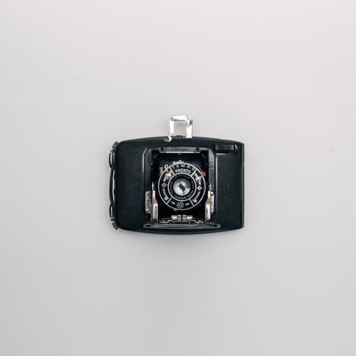 白色表面上的黑色和灰色相机 · 免费素材图片