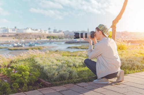 男子用单反相机拍照 · 免费素材图片