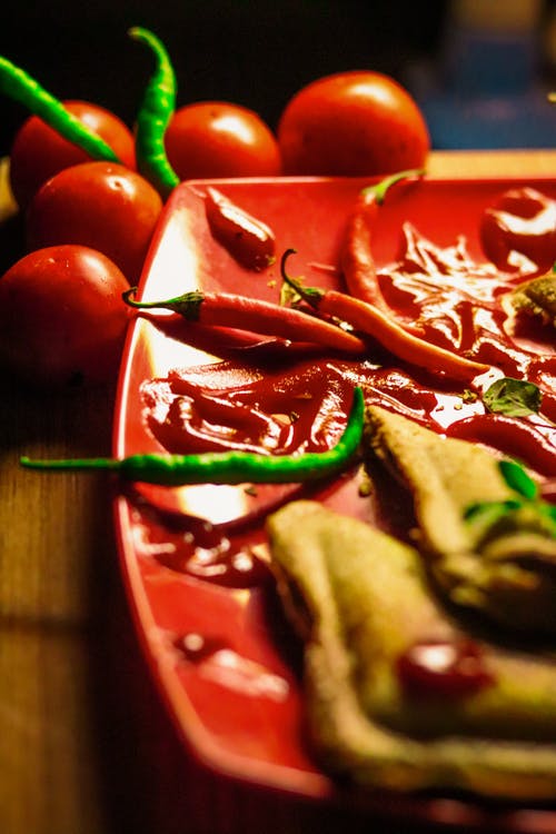 板上绿色和红色辣椒的浅焦点摄影 · 免费素材图片