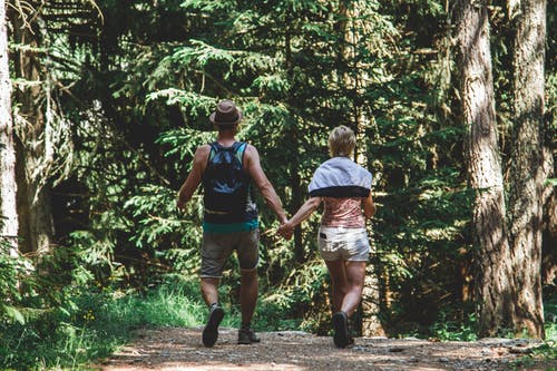 男人和女人在森林里散步 · 免费素材图片