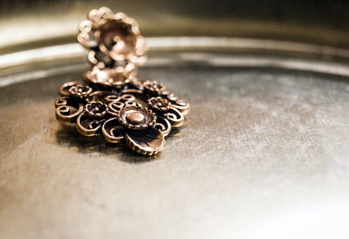 棕色表面上的棕色花卉压花金属装饰 · 免费素材图片