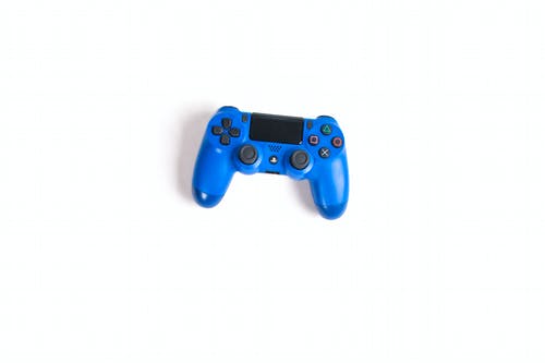 白色表面上的蓝色sony Dualshock 4 · 免费素材图片