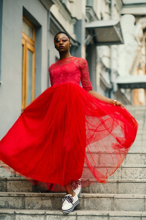 在楼梯上行走的女人穿红色肘袖连衣裙 · 免费素材图片