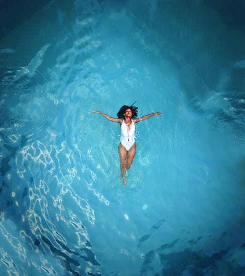 在水中游泳的白色monokini的女人 · 免费素材图片