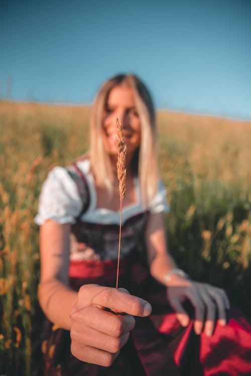 女人抱着小麦的选择性聚焦摄影 · 免费素材图片