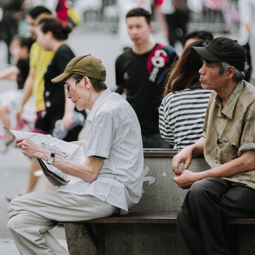 男子坐在室外的椅子上的选择性聚焦摄影 · 免费素材图片