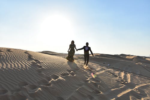 女人和男人站在沙漠上 · 免费素材图片