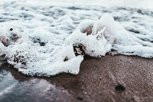 海浪击碎岩石的特写照片 · 免费素材图片