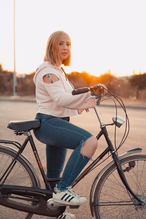 女人骑自行车的浅焦点照片 · 免费素材图片