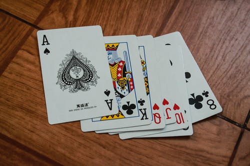 棕色木质表面上的七种什锦的扑克牌 · 免费素材图片