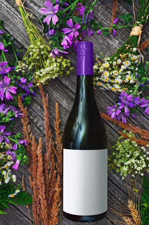 葡萄酒瓶附近花的照片 · 免费素材图片