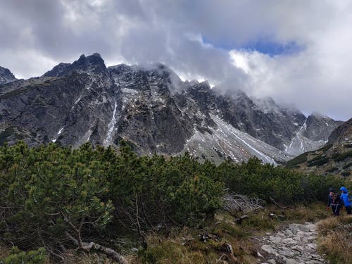 两人站在山前的自然摄影 · 免费素材图片