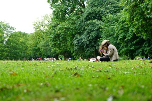 人们坐在绿草地上 · 免费素材图片
