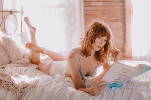 女人在床上读书的照片 · 免费素材图片