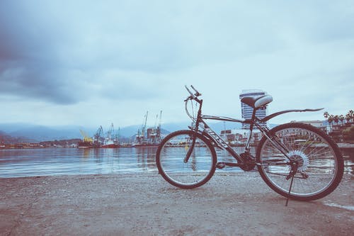 靠近水的黑色自行车 · 免费素材图片