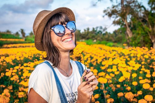 女人拿着黄色的花瓣花 · 免费素材图片