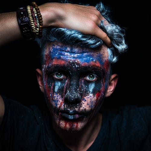 一个男人脸上涂满颜料的特写照片 · 免费素材图片
