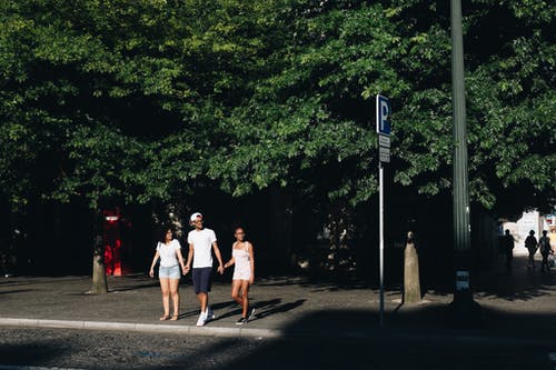 该名男子手持两个女人的双手站立时 · 免费素材图片