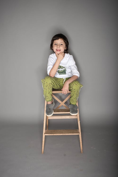 男孩坐在椅子上的照片 · 免费素材图片