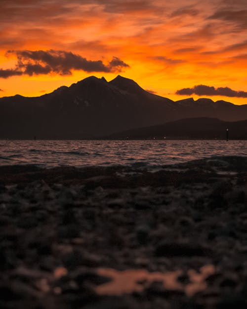 橙色日落期间山的轮廓 · 免费素材图片