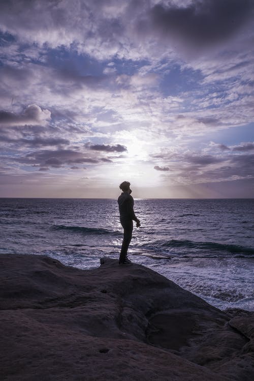 男子站在岩层上的照片 · 免费素材图片