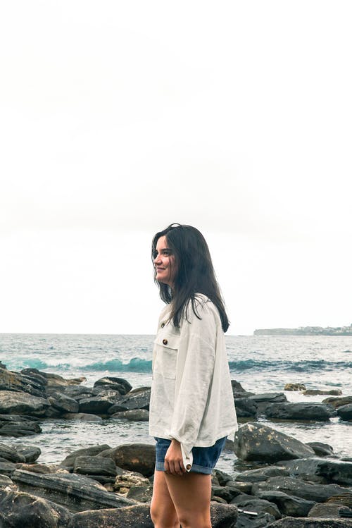 微笑着站在岸上的女人 · 免费素材图片