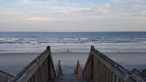 海滨与波附近的灰色木制楼梯 · 免费素材图片