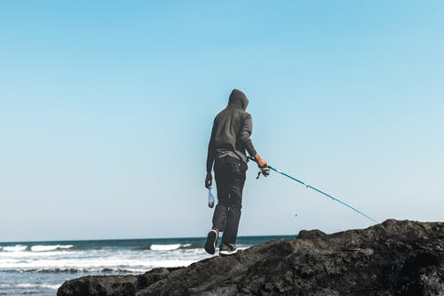 在海边钓鱼的人 · 免费素材图片