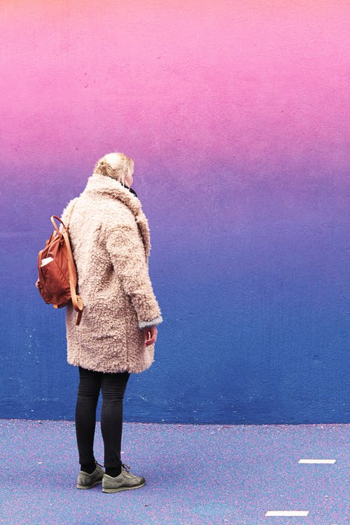 站在粉红色和蓝色的墙前的女人 · 免费素材图片