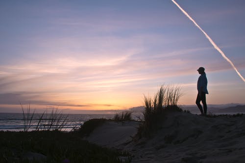 黎明时站在沙滩上的人的照片 · 免费素材图片