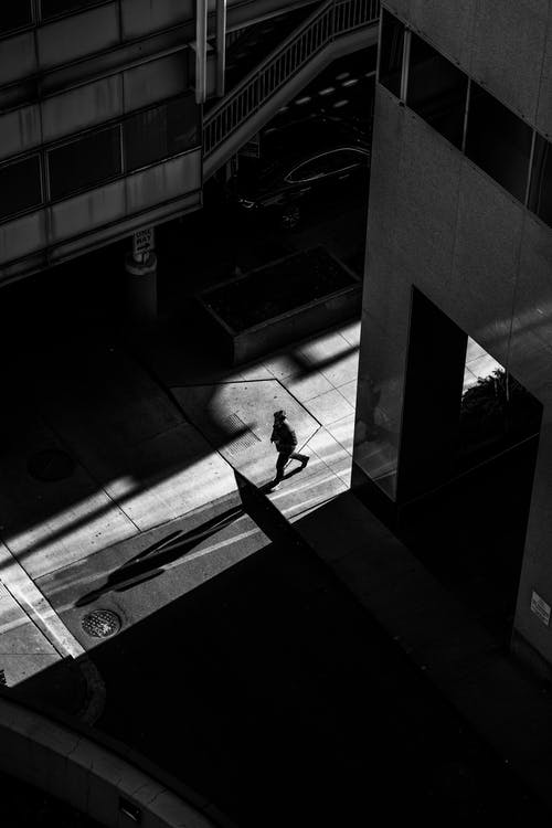在建筑物附近的街道上行走的人的灰度照片 · 免费素材图片