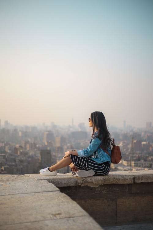 女人坐在建筑物的边缘 · 免费素材图片