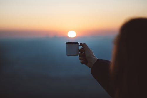 显示白色杯子的人在焦点摄影 · 免费素材图片