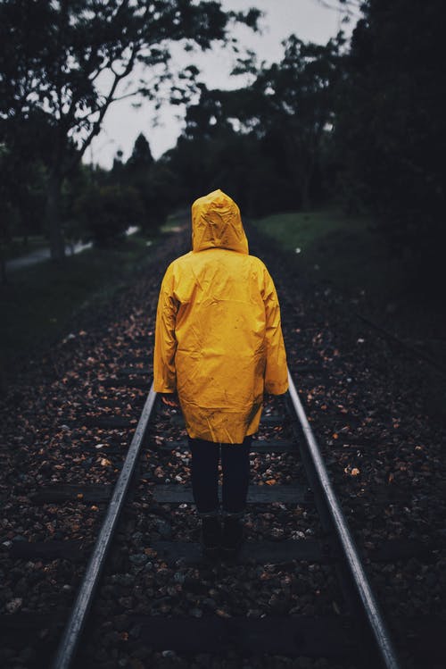铁路上穿着雨衣的人的照片 · 免费素材图片
