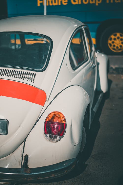 经典白色大众甲壳虫双门跑车停在车辆附近 · 免费素材图片