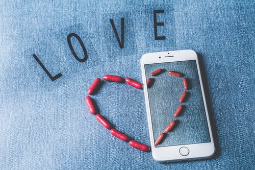 银色iphone 6旁边的爱独立字母 · 免费素材图片