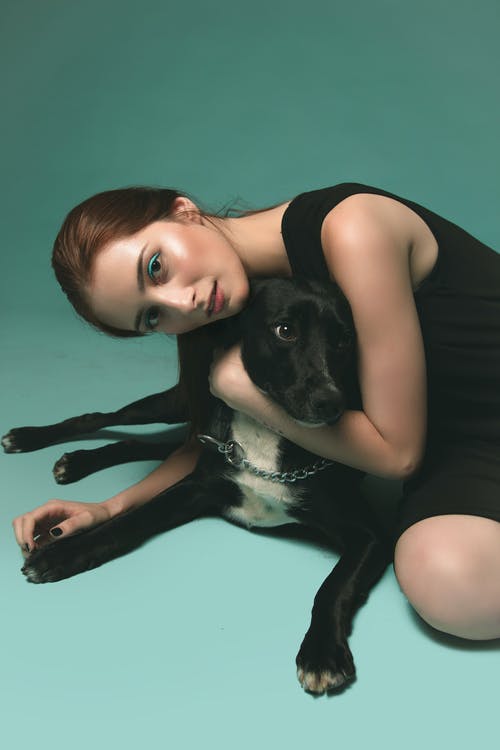 女人抱着一只狗的照片 · 免费素材图片