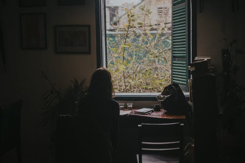 女人坐在椅子上看外面的特写照片 · 免费素材图片