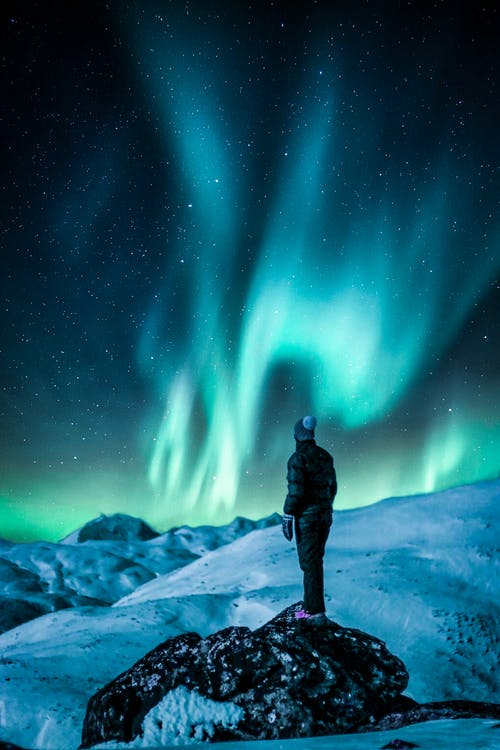 男子站在雪原附近 · 免费素材图片