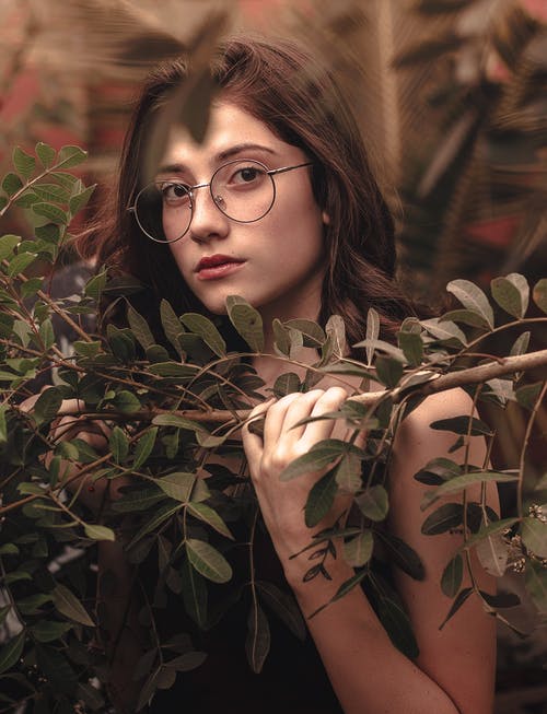 戴灰色眼镜拿着树的女人 · 免费素材图片