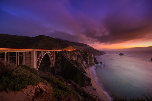日落海滩上的金属桥 · 免费素材图片