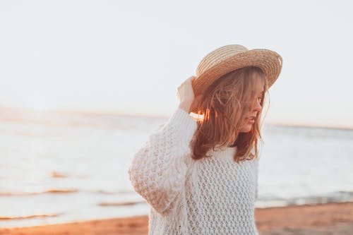 女人拿着棕色草帽的选择性焦点摄影 · 免费素材图片