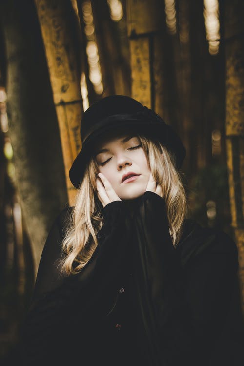 女人戴着黑帽子和外套的选择性聚焦摄影 · 免费素材图片