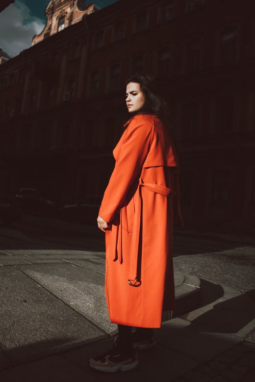 穿橙色外套站在路面上的女人 · 免费素材图片