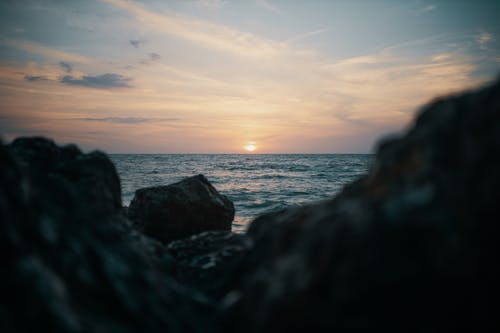 海洋附近的石头的选择性聚焦摄影 · 免费素材图片