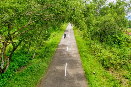 人骑摩托车沿路航拍 · 免费素材图片